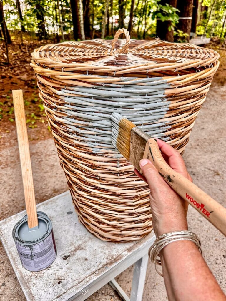 Laundry basket DIY with lid with someone painting it a blue gray color.