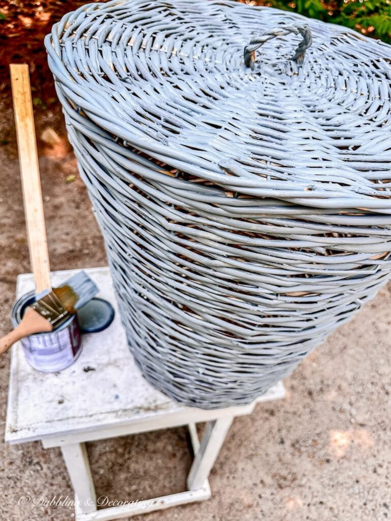 Basket DIY painted in blue on painting table after one coat of paint.