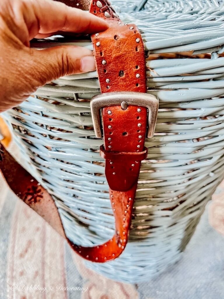 Leather belt aligned with hand on blue basket DIY.