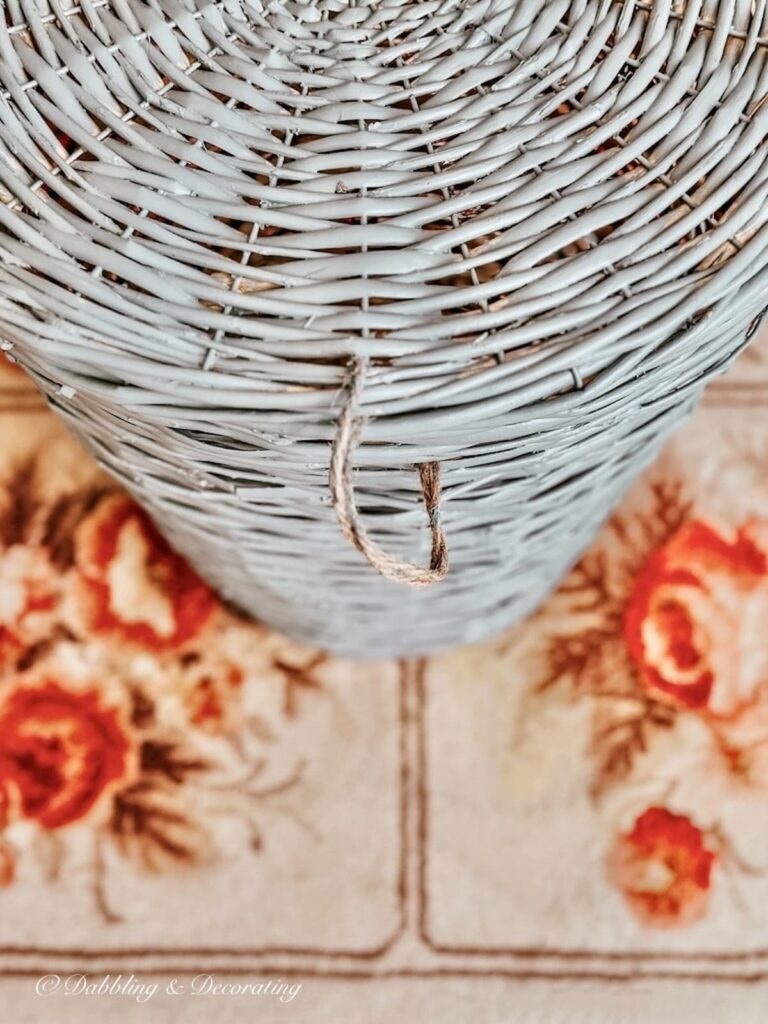 Blue basket with jute twine on rose rug.