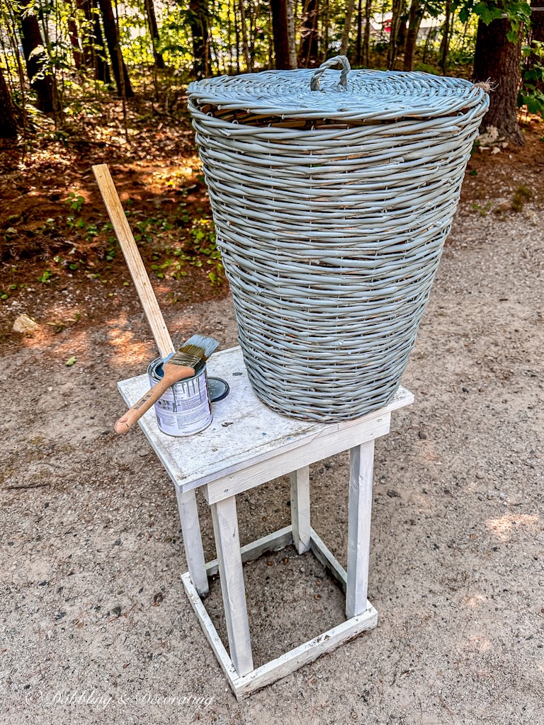 Basket DIY painted in blue on painting table after one coat of paint.