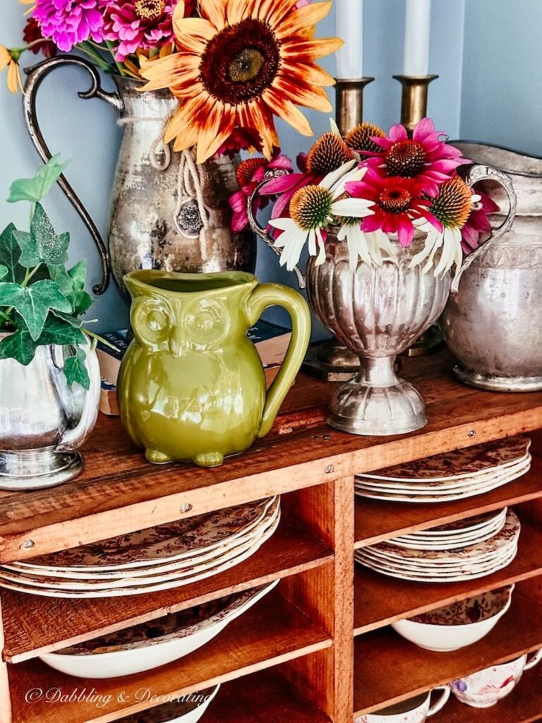 Wooden Pie Safe with vintage decor accessories and flowers.