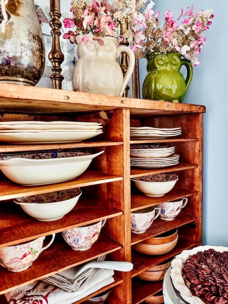 Vintage wood pie safe with dishes and vintage details in kitchen corner counter top.