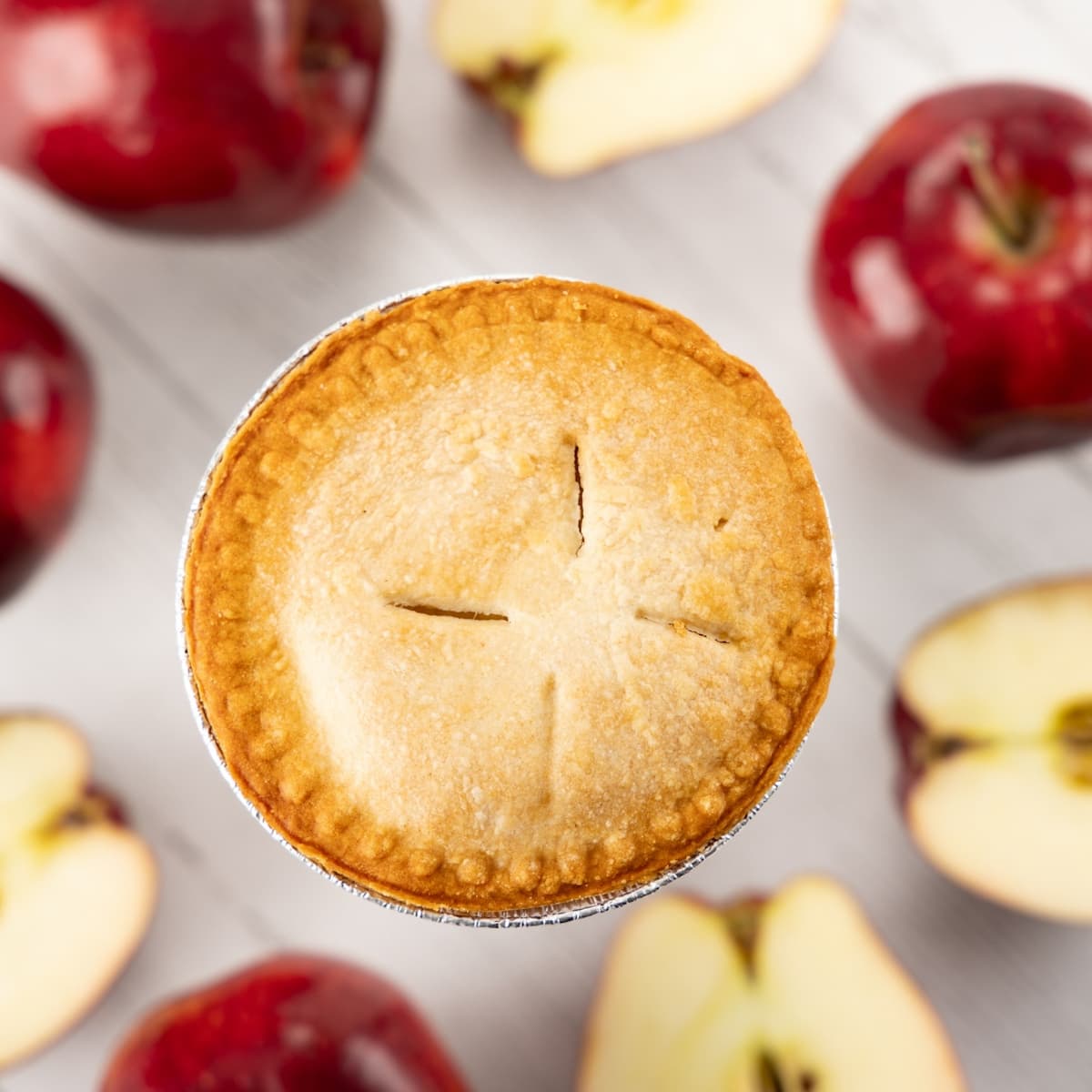 Fresh Table Top Pie surrounded by apples.