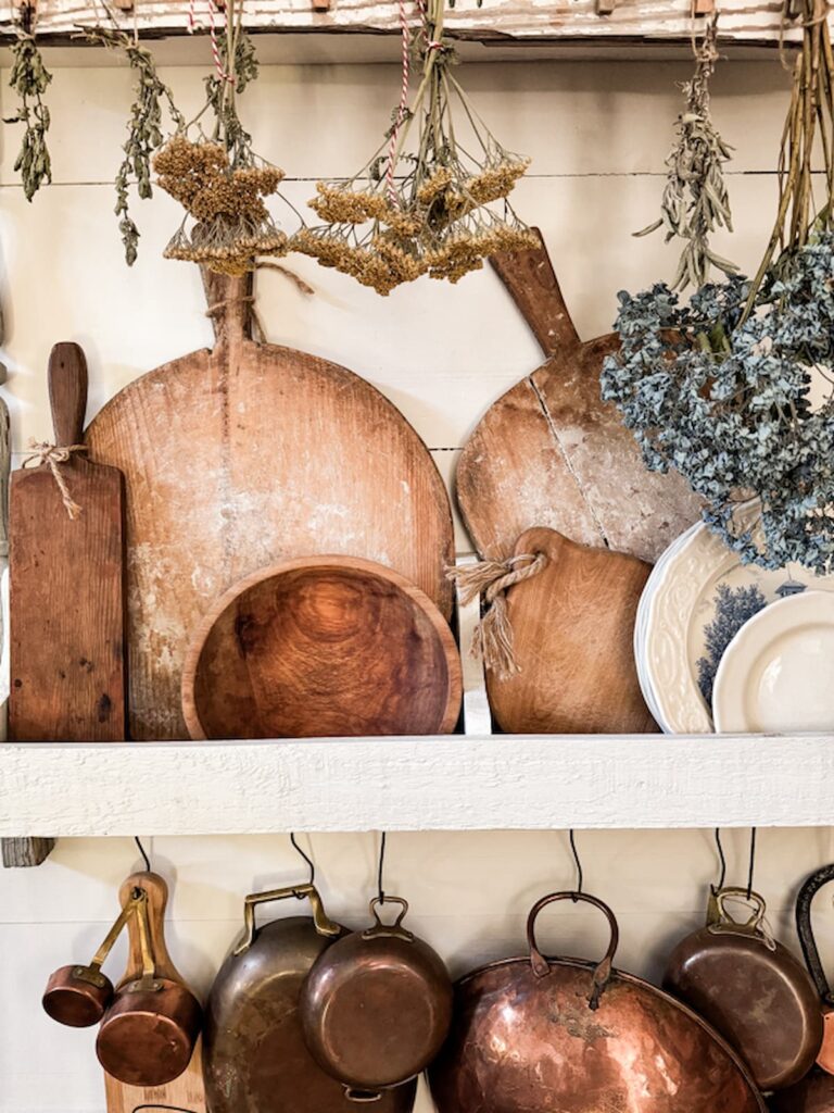 Vintage breadboards on farmhouse kitchen shelving.