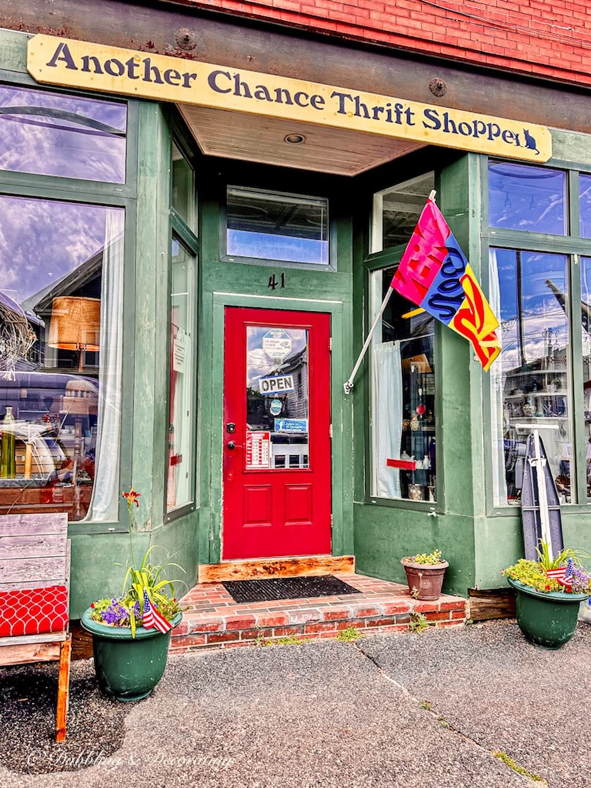 Another Chance Thrift Shoppe. Green shop with red door and open flag.