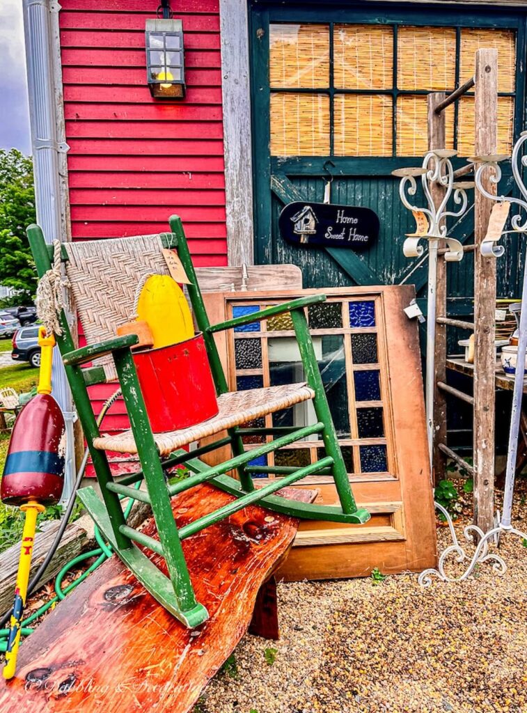 Green rocking chair with colorful lobster buoy at Sage Farm Antiques Outdoor vintage pop-up.