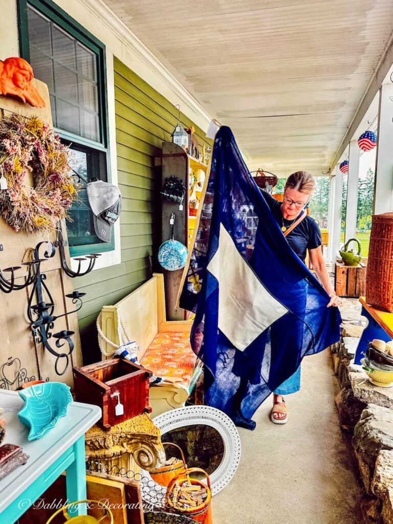 Woman holding a Papa Flag blue and white nautical flag at Sage Farm Antiques.