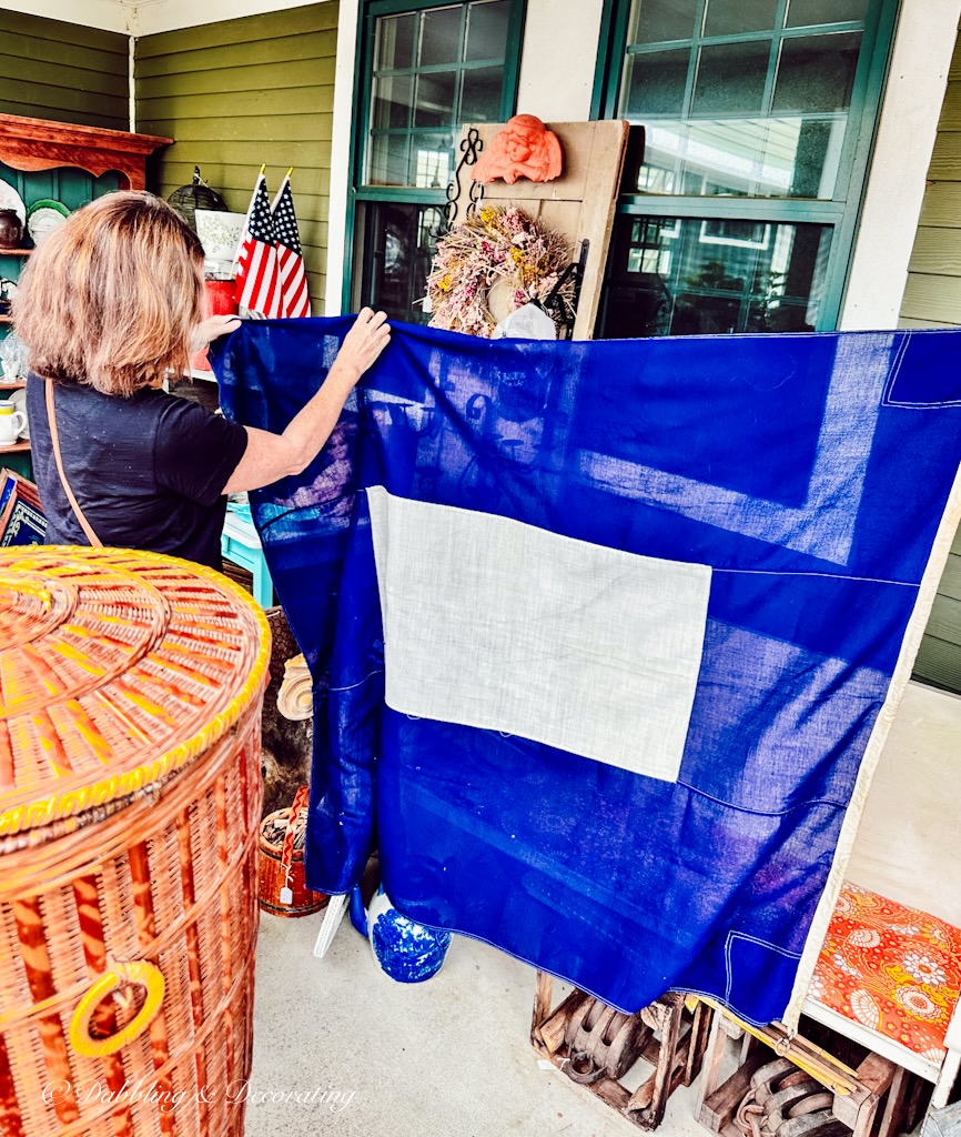 woman holding a Papa Flag blue and white nautical flag at Sage Farm Antiques.