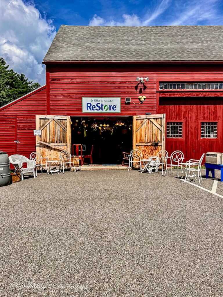 Habitat for Humanity Restore. A red barn with doors open and antiques outside.