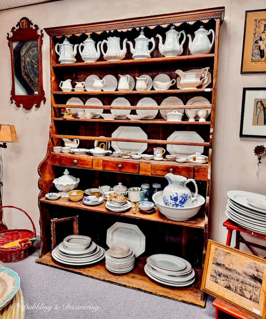 Ironstone collection in pine hutch in antique store.