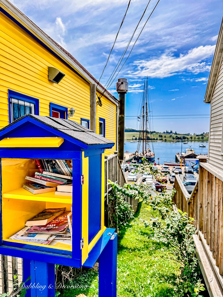 Yellow and blue trimmed home on Nova Scotia Road Trip with Free Library.