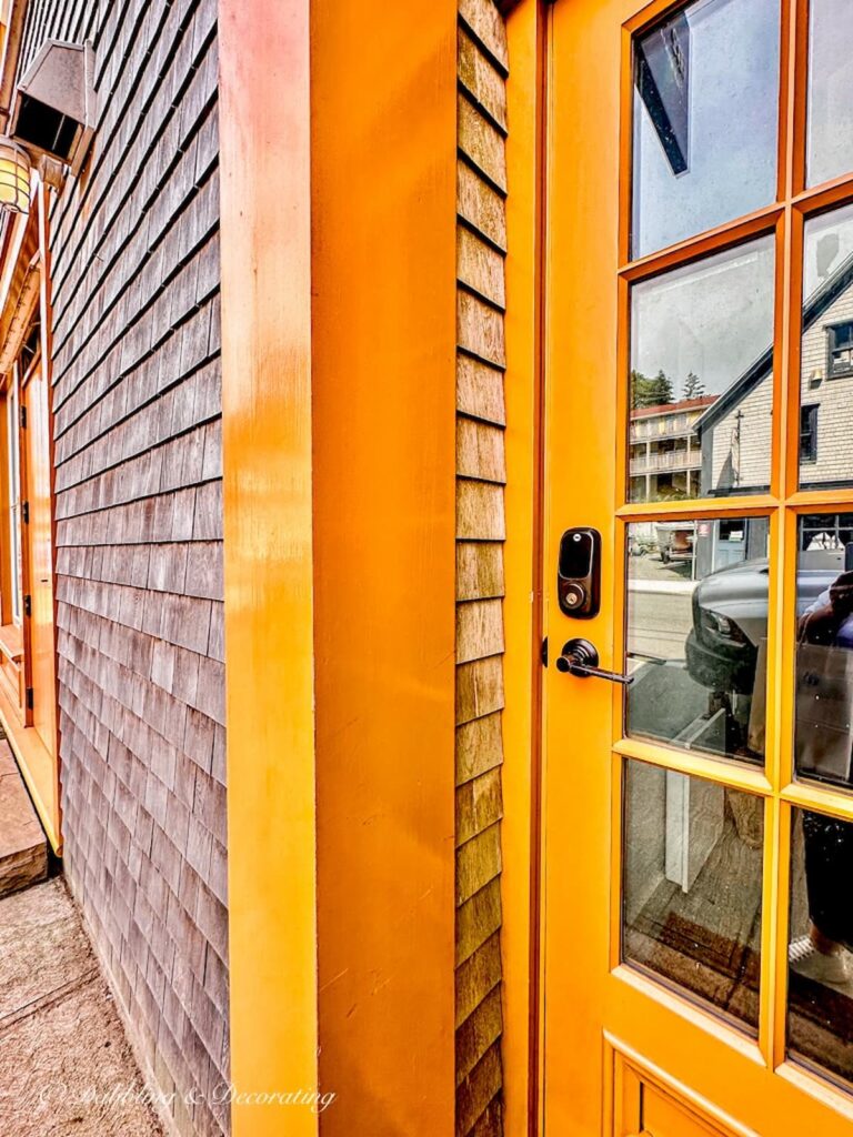 Orange door with cedar shakes on exterior home on Nova Scotia Road Trip.