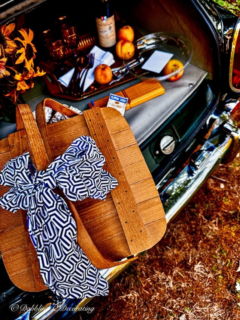 Picnic Basket with blue and white scarf tied in bow at outdoor car picnic.