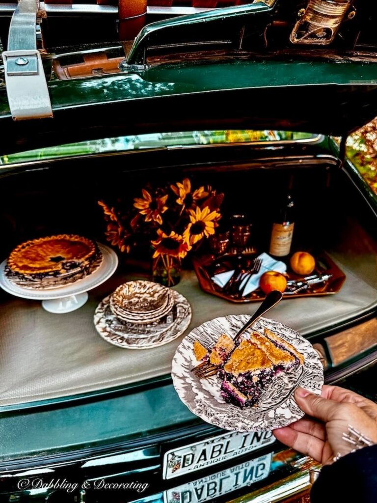 Vintage brown and white transferware dish with blueberry pie at outdoor car picnic trunk display.