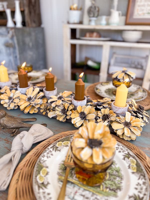 Sunflower pinecones table centerpiece with candles.