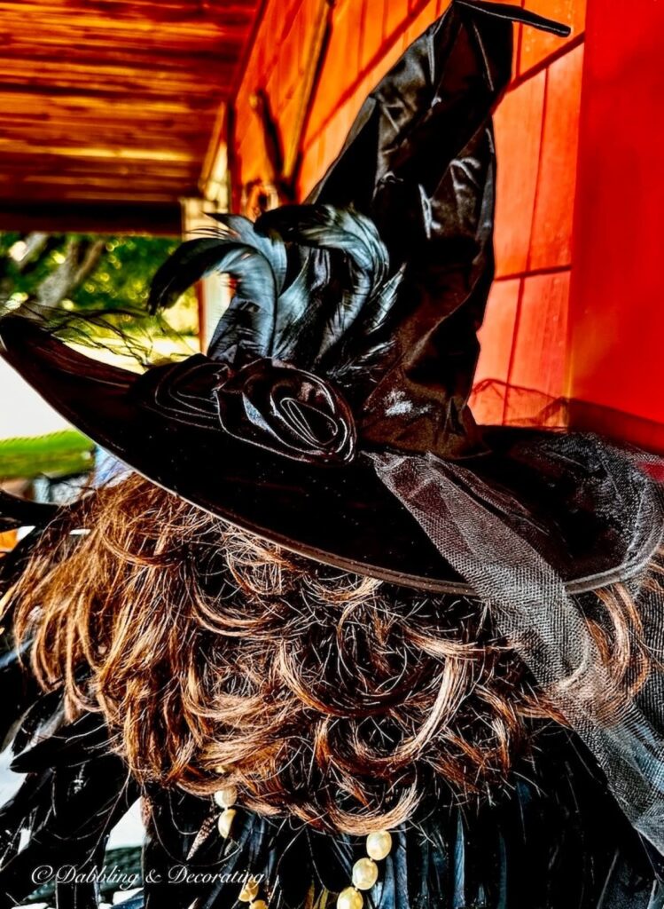 Witches hat over brown hair close up of witchy decor.