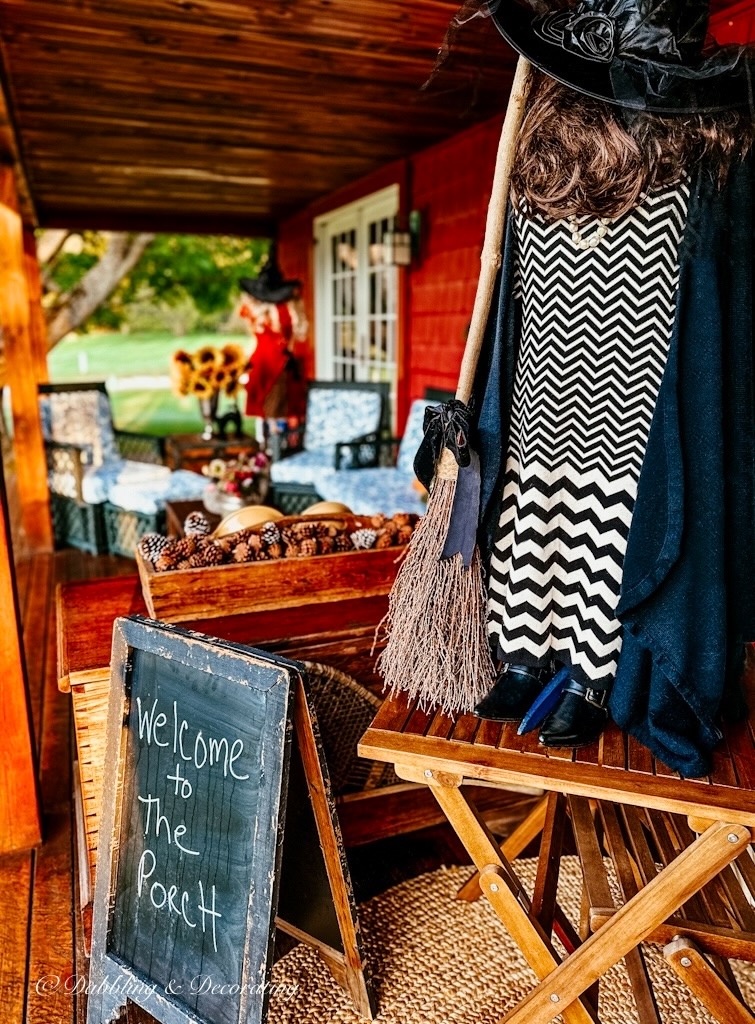 Mannequin witchy decor on front porch for Halloween.