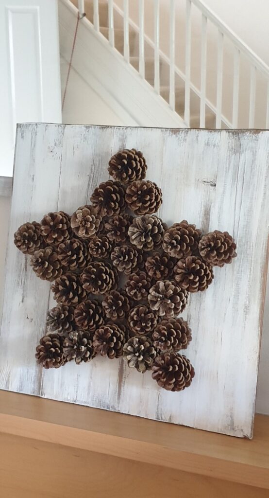 Pinecone decor Star on white board DIY project.