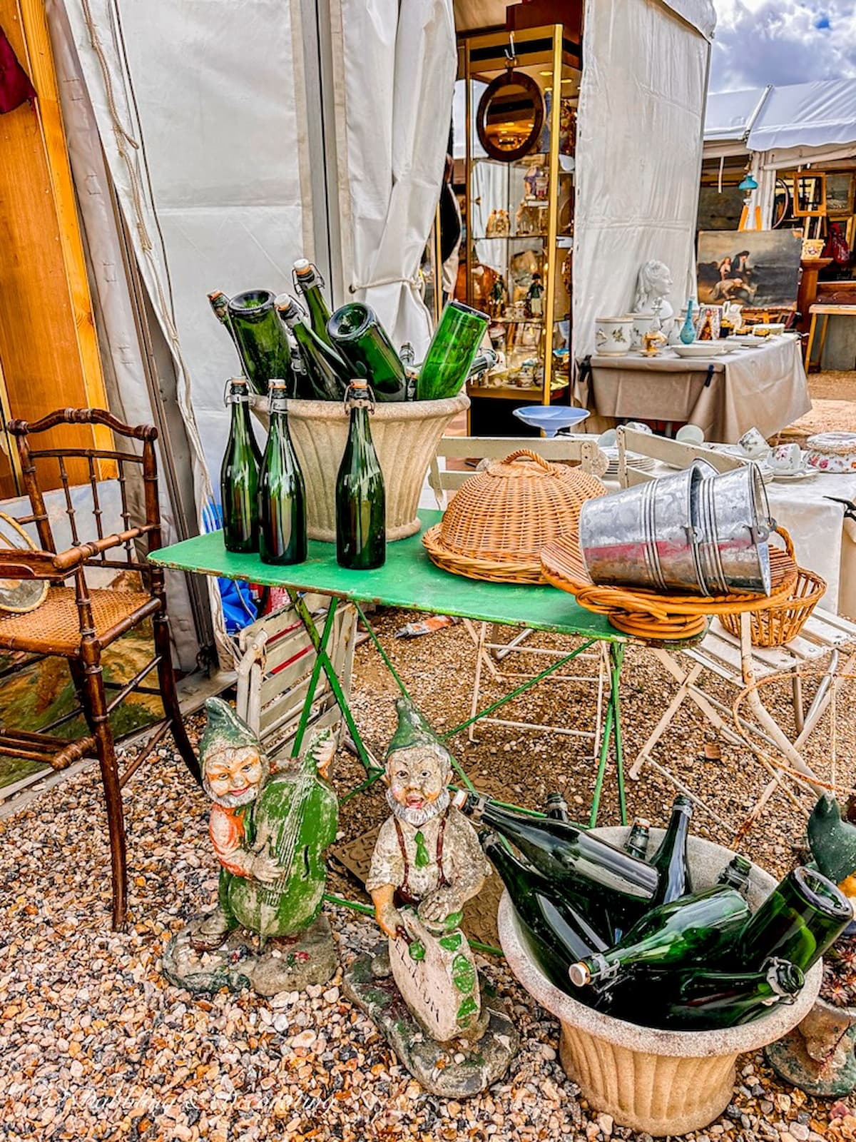 Flea market display in Paris France with Green bottles and baskets.