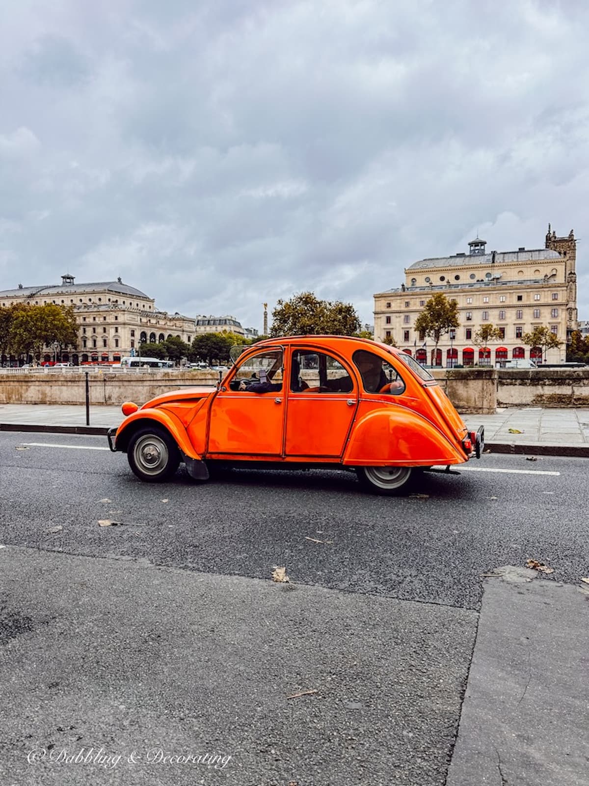 Orange small French car on road in Paris.