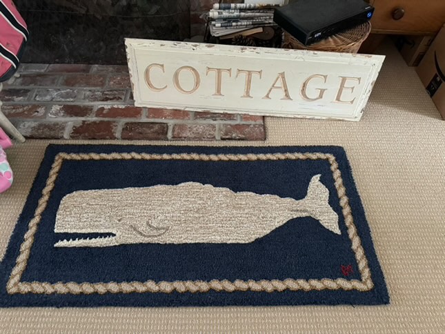 Blue whale rug in front of fireplace.