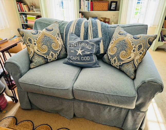 Blue Four Season love seat with paisley pillows in living room.