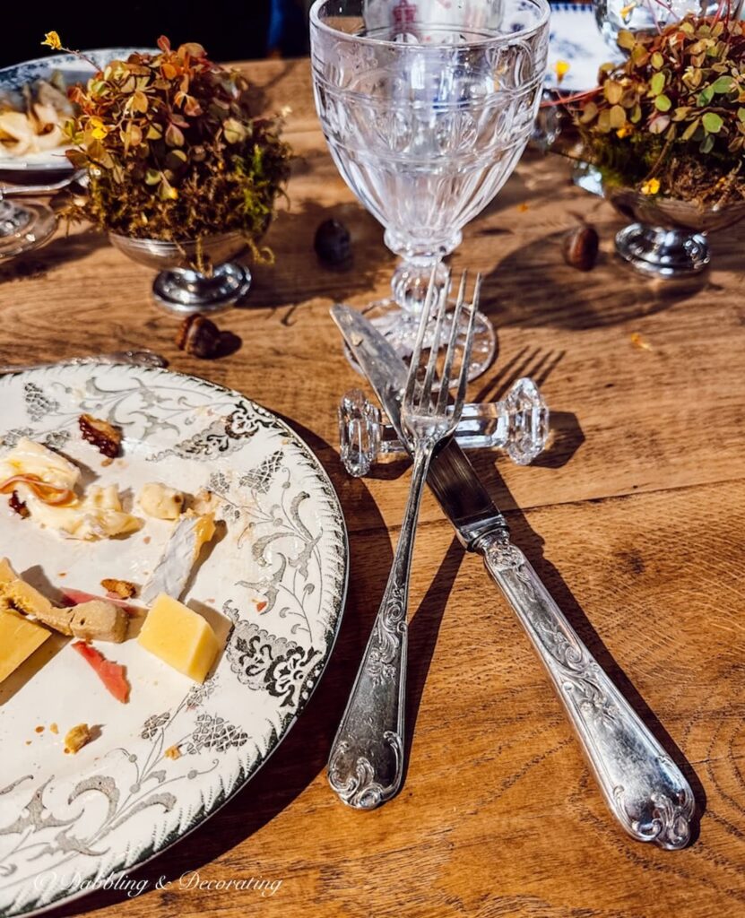 Place setting on wooden table with dirty silverware resting on French knife rest.