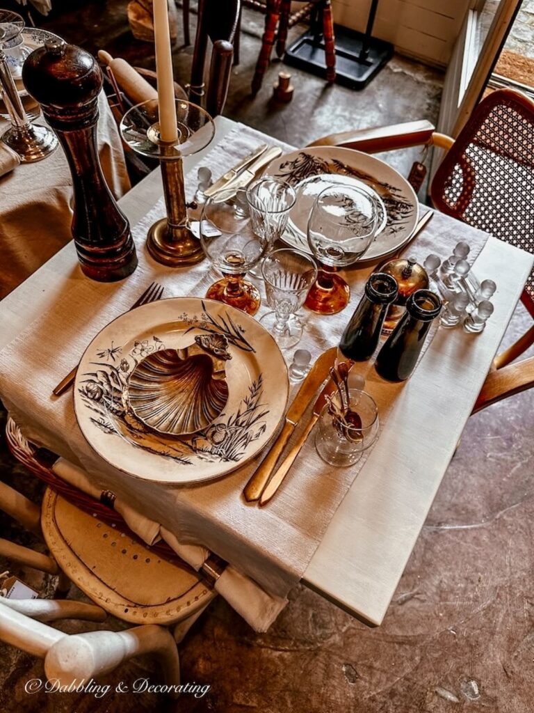 Gold flatware on brown table setting with knife rest in France.