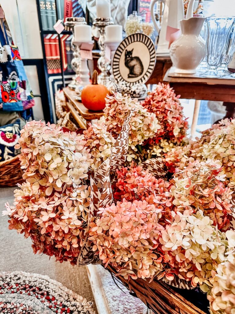 Basket of bundled and tissue wrapped fall hydrangeas in vintage booth for sale.