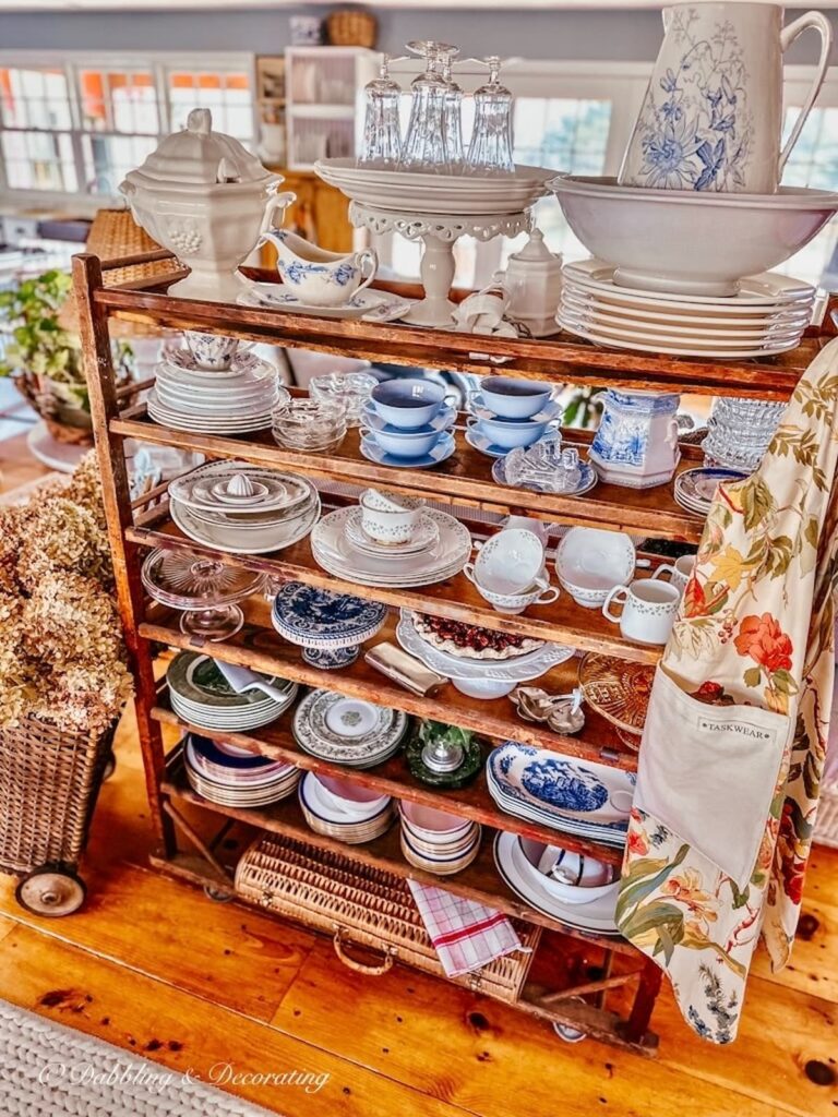 Vintage cobbler rack with antique dishware decorated in open floor plan home.