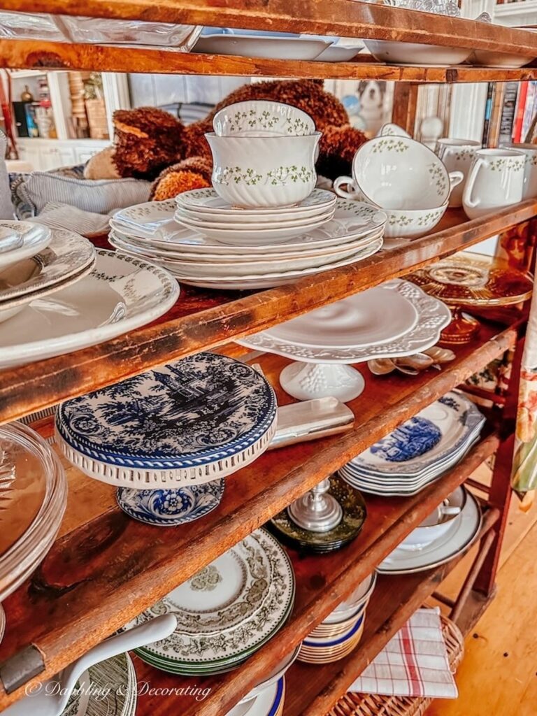 Vintage cake stands lined up on vintage cobbler rack shelf.