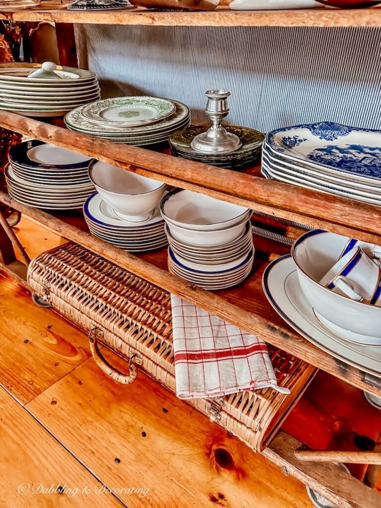 Antique cobbler rack with old fashioned dinnerware pieces.