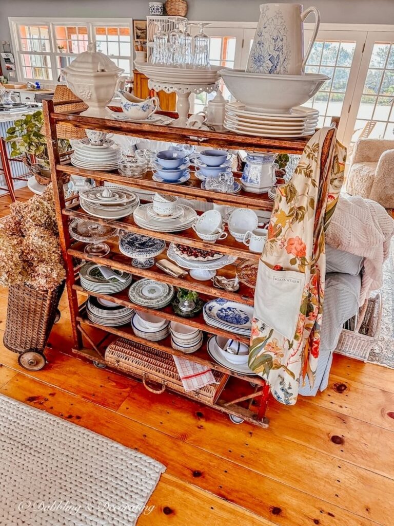 Vintage cobbler rack with antique dishware decorated in open floor plan home.