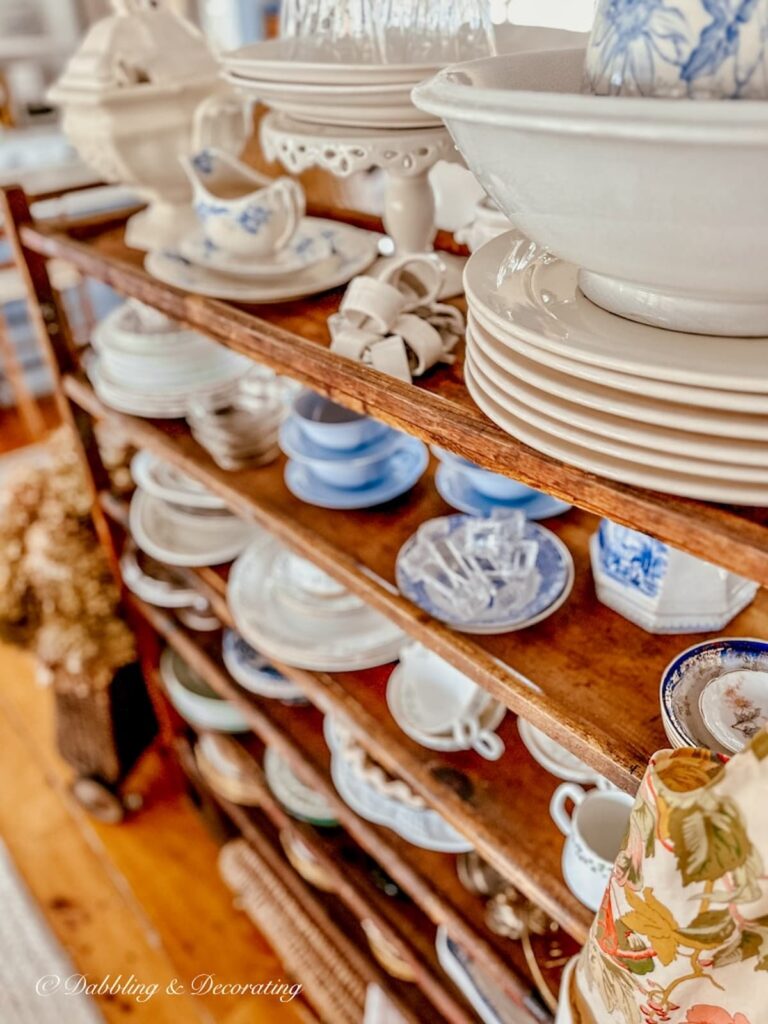 Vintage collections displayed on a wooden cobbler rack in vintage home decor.