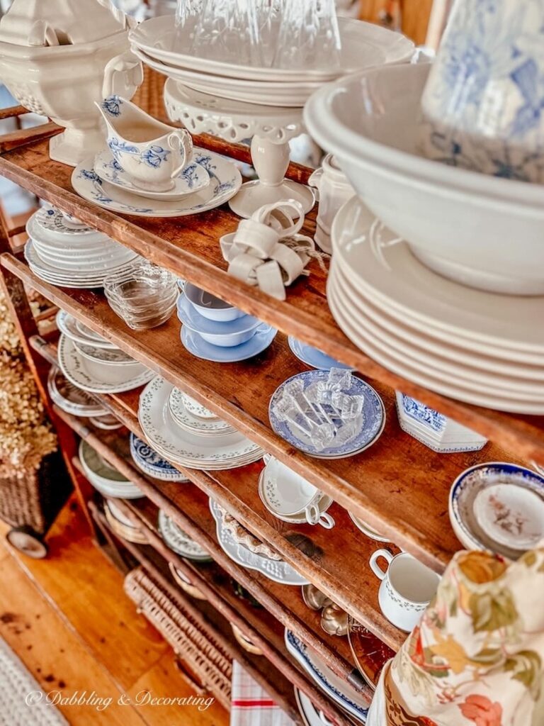 Vintage cobbler rack with ironstone decorated in open floor plan home.