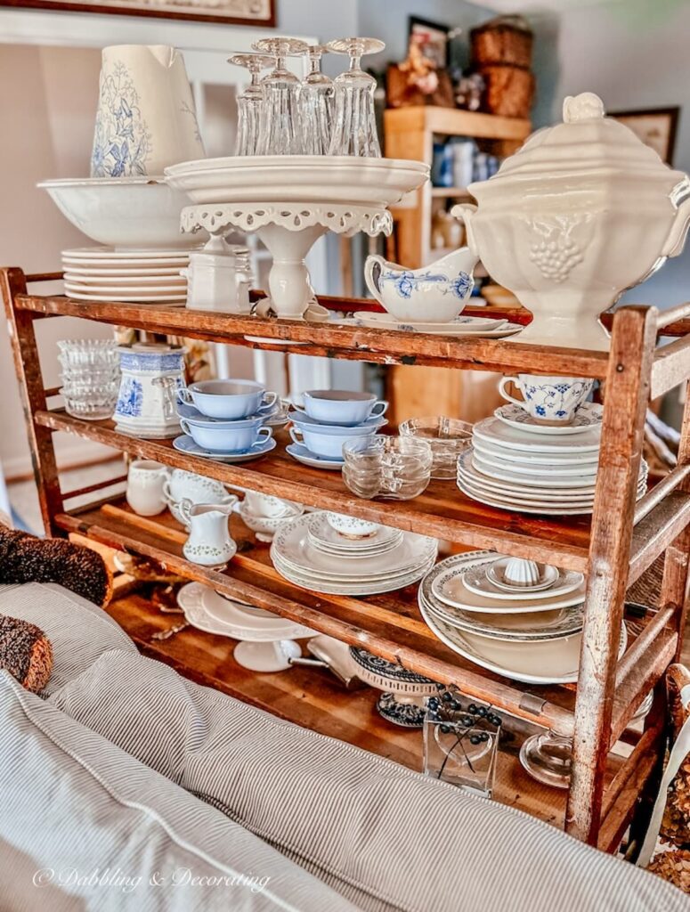 Vintage collections displayed on a wooden cobbler rack in vintage home decor.