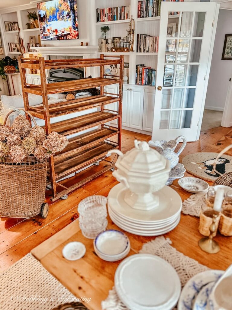 Vintage cobbler rack in open floor plan home with vintage collections on table.