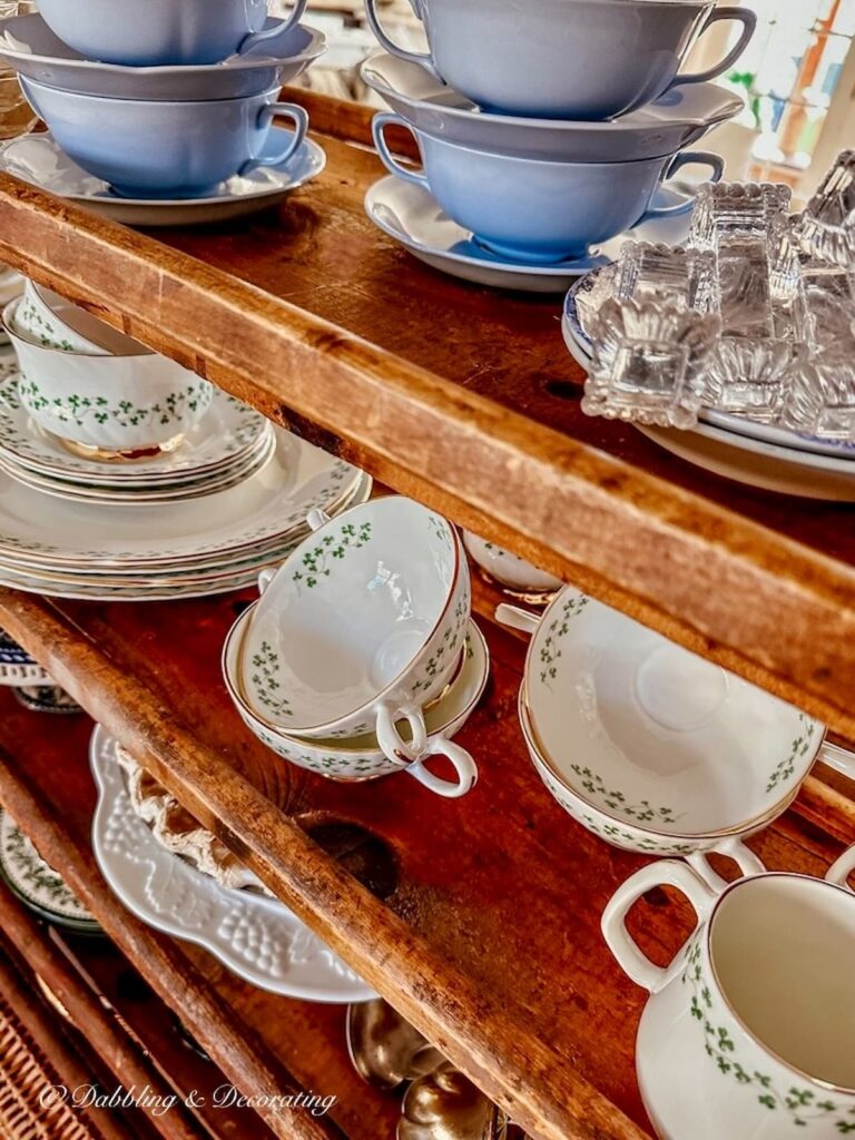 Irish Royal Tara dinnerware displayed on middle shelf of vintage cobbler rack.