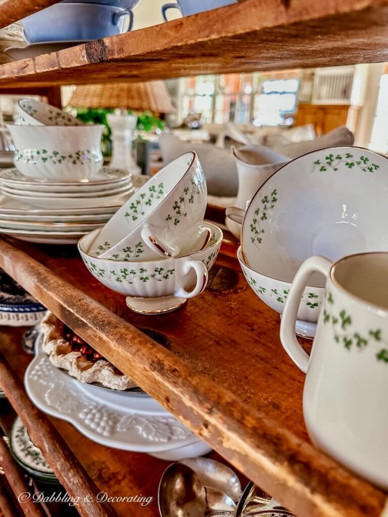 Irish Royal Tara dinnerware displayed on middle shelf of vintage cobbler rack.