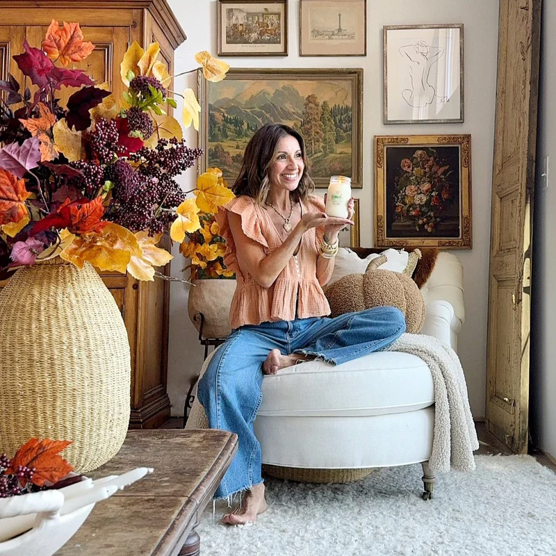 Woman holding a Candle in Fall Decor.