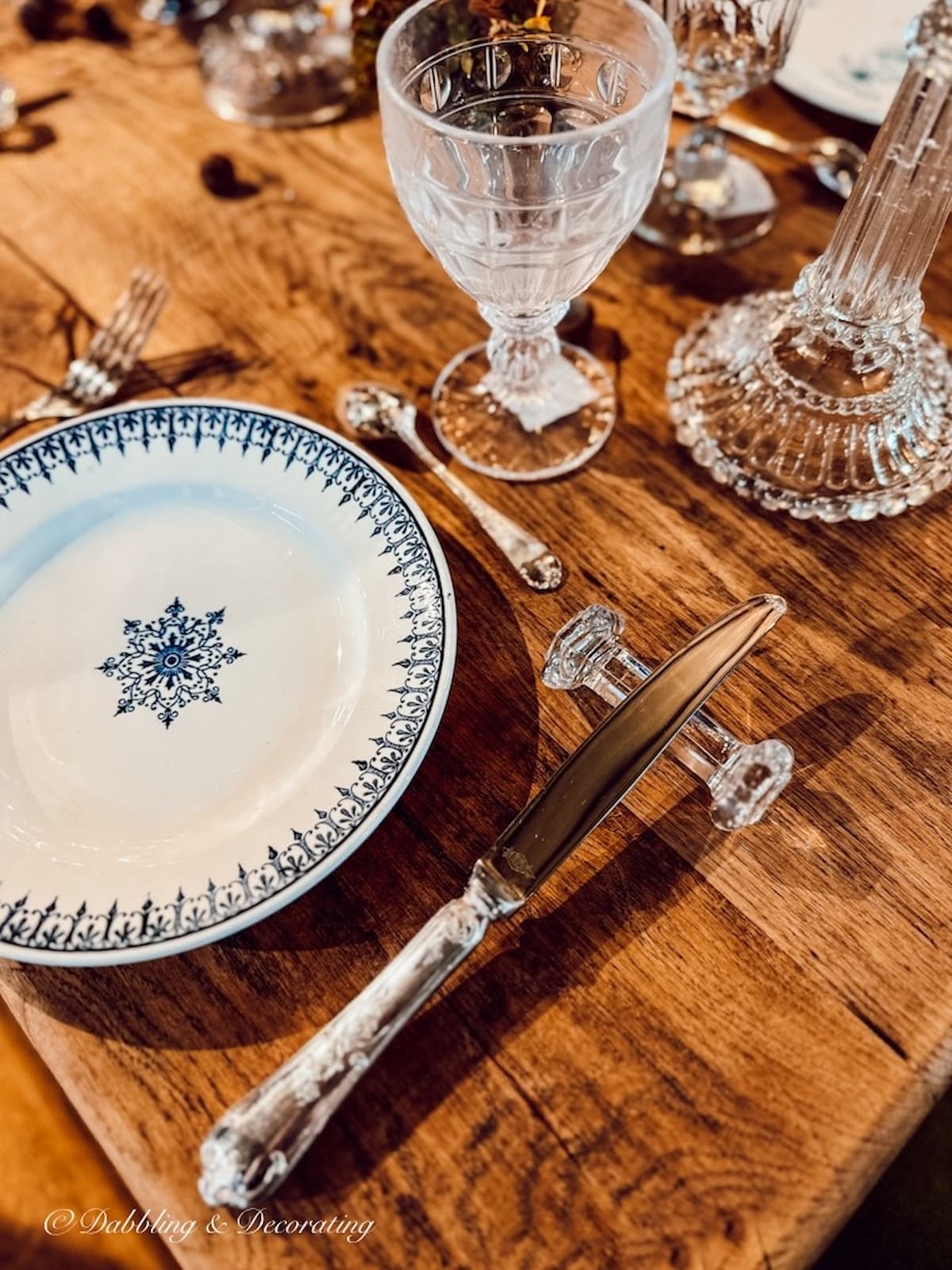 Crystal knife rest with silver knife in French place setting.