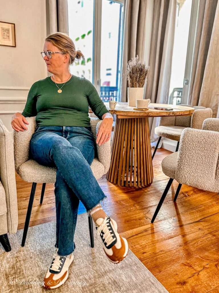 Woman sitting in chair at Paris apartment.