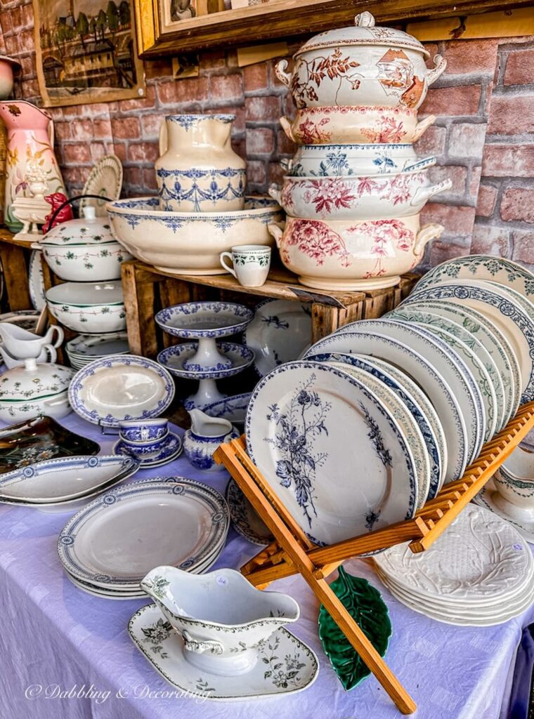 Antique soup tureens stacked at Paris antiques market.