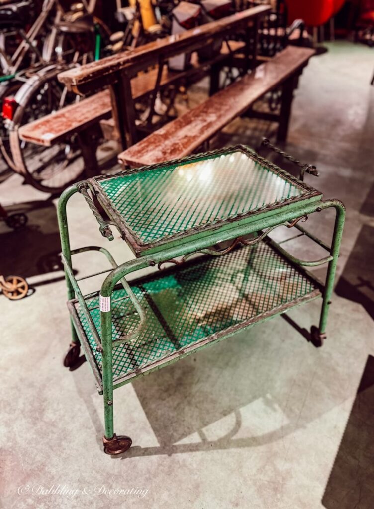 Antique green bar cart at antique warehouse in Paris France.