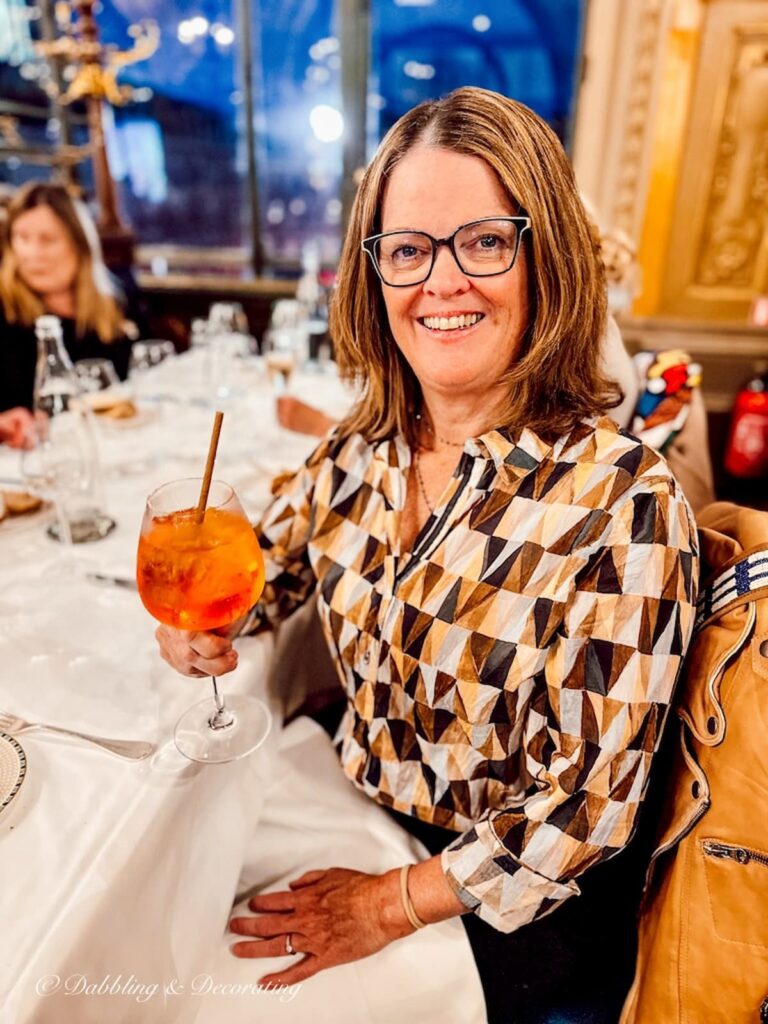 Girl holding a drink at Le Train Bleu Restaurant.