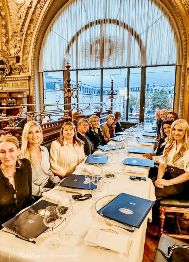 A large table of people at the restaurant Le Train Bleu in Paris France.