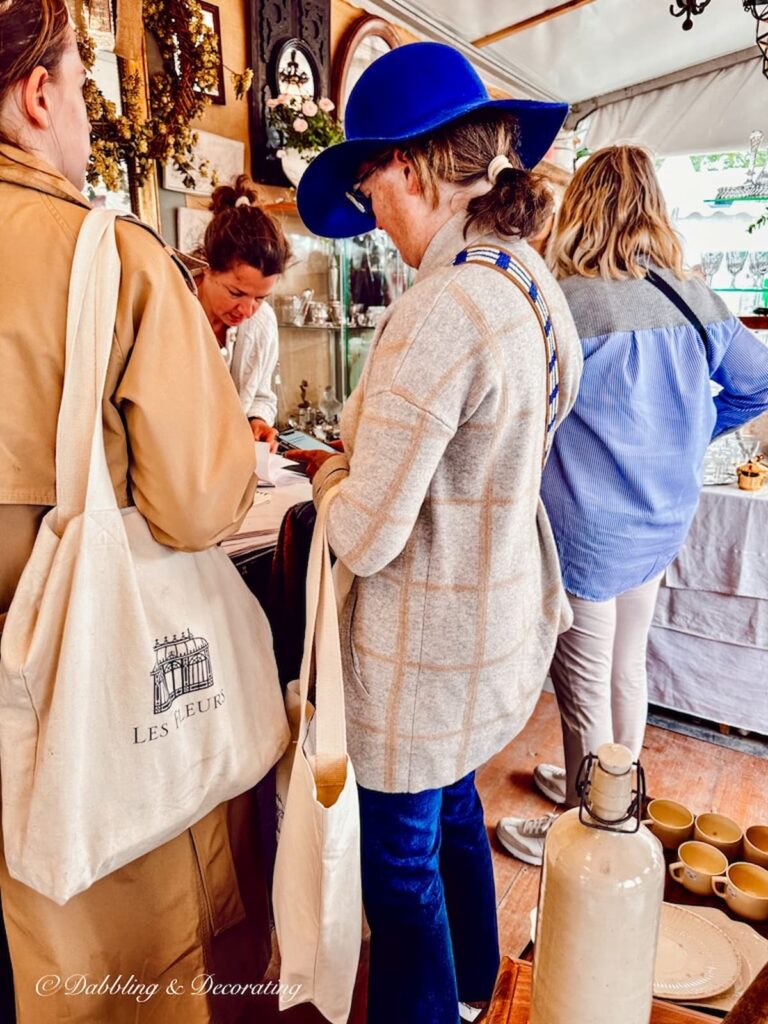 Two women checking out at Paris Antiques flea market booth.