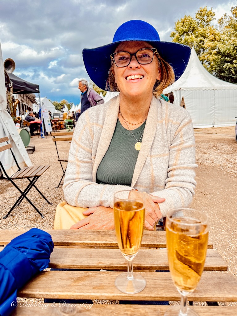 Woman at table with champagne at Paris flea market.