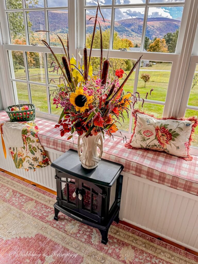 Bouquet of Fall Foraged flowers next to Vermont fall foliage in the mountains backdrop.